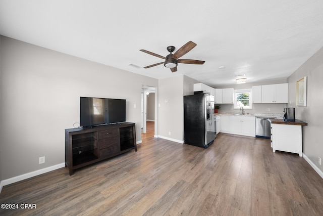 kitchen featuring sink, dark wood-type flooring, ceiling fan, appliances with stainless steel finishes, and white cabinets