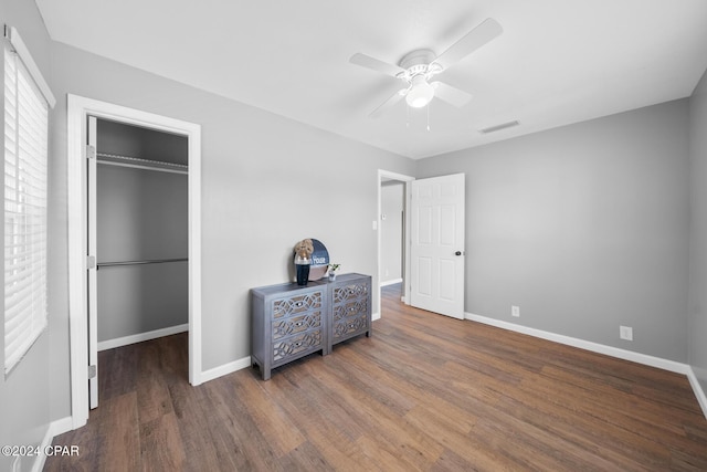 bedroom featuring ceiling fan, a spacious closet, dark hardwood / wood-style flooring, and a closet