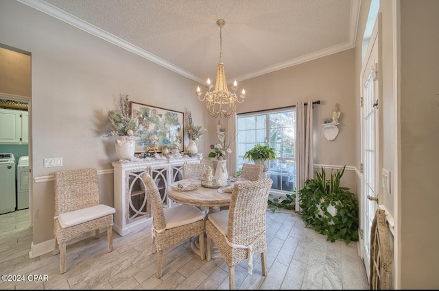 dining space featuring washer and clothes dryer, light wood-type flooring, ornamental molding, a textured ceiling, and a notable chandelier