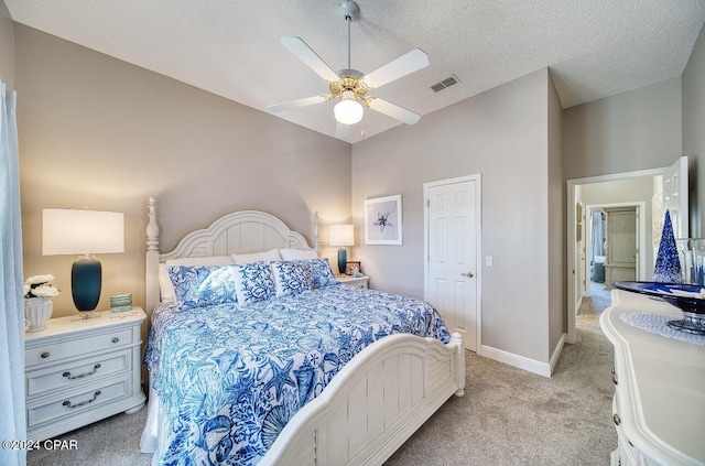 carpeted bedroom featuring ceiling fan and a textured ceiling