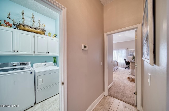 washroom featuring cabinets, independent washer and dryer, and a textured ceiling