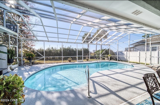 view of swimming pool featuring a lanai and a patio