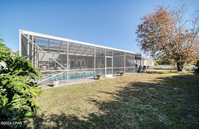 view of swimming pool with glass enclosure and a yard