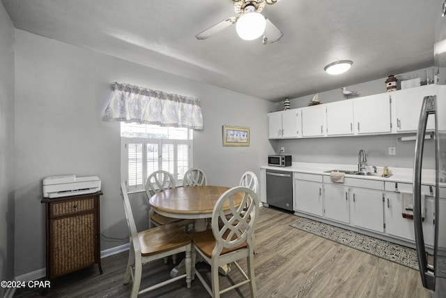 dining room featuring light hardwood / wood-style floors, ceiling fan, and sink