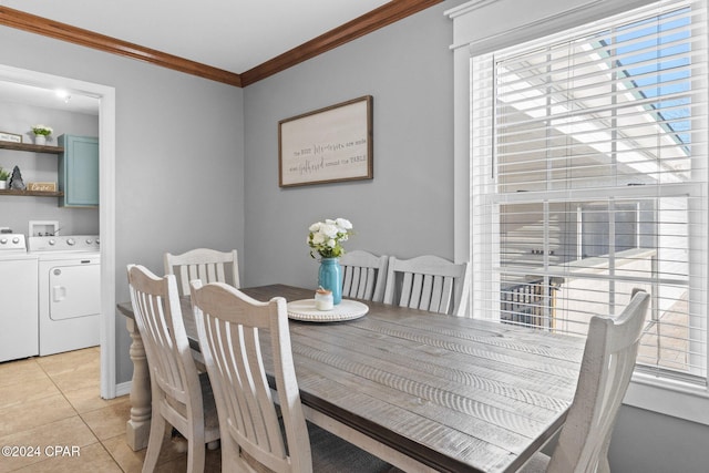 tiled dining space with separate washer and dryer and crown molding