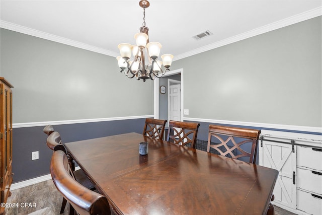 dining room with a chandelier, hardwood / wood-style floors, and ornamental molding