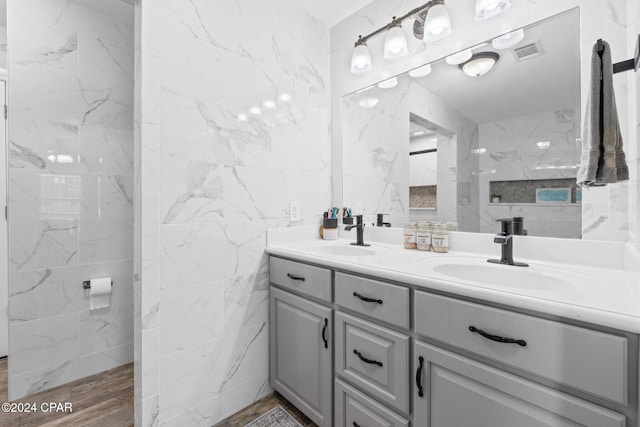 bathroom with vanity and tile walls