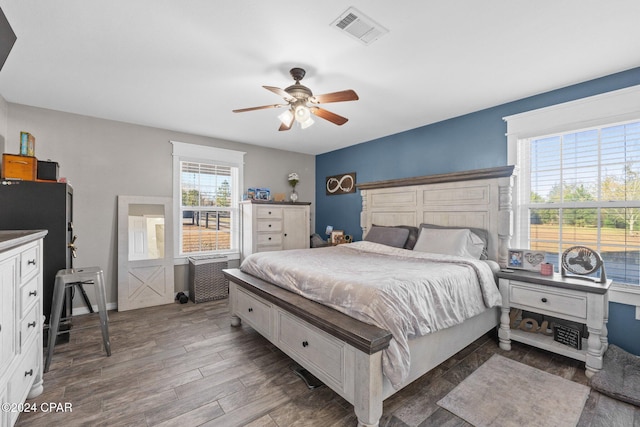 bedroom with multiple windows, hardwood / wood-style floors, and ceiling fan