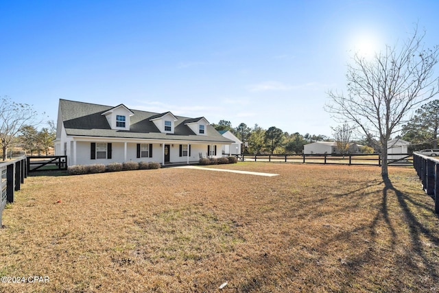 cape cod home featuring a front yard