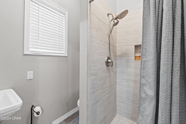 bathroom featuring a shower with curtain, sink, and toilet