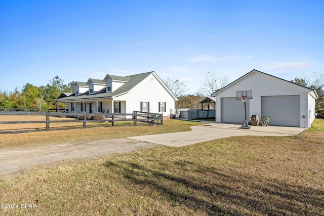 view of front of home featuring a porch, a garage, an outdoor structure, and a front lawn