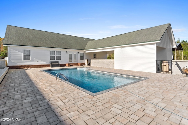 view of pool with french doors and a patio area