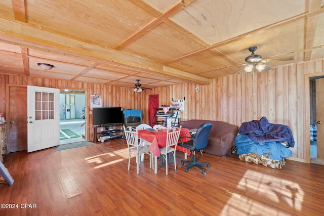 dining space featuring ceiling fan, beam ceiling, wooden ceiling, hardwood / wood-style floors, and wood walls