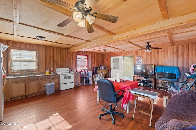 home office featuring beamed ceiling, plenty of natural light, and wooden walls