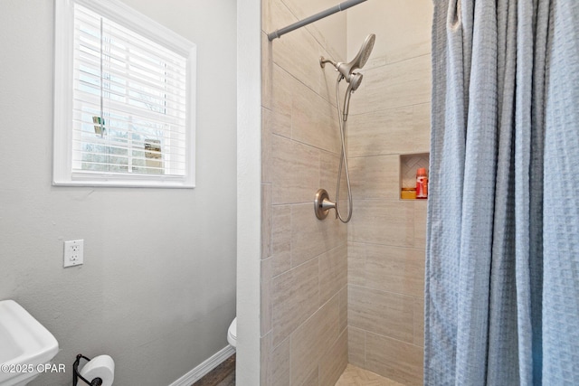 bathroom with a shower with shower curtain and toilet