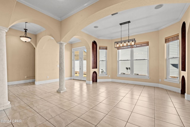 interior space featuring ornate columns, crown molding, a wealth of natural light, and french doors