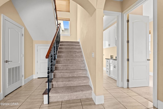 stairway with carpet flooring and lofted ceiling