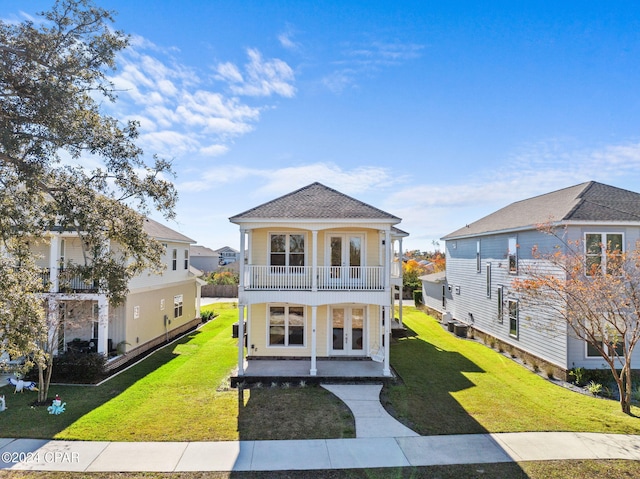 view of front of home featuring french doors, a porch, a balcony, and a front yard