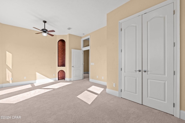 unfurnished bedroom featuring ceiling fan and light colored carpet