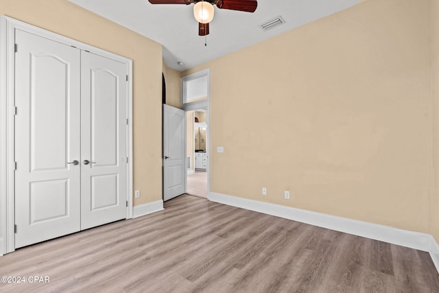 unfurnished bedroom with ceiling fan, a closet, and light hardwood / wood-style flooring