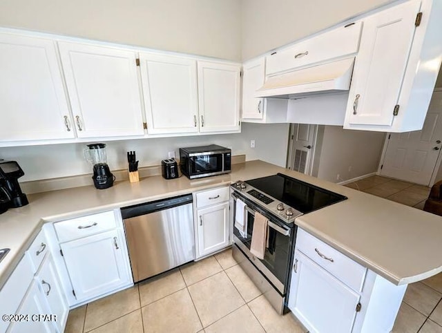 kitchen featuring white cabinets, light tile patterned floors, stainless steel appliances, and custom range hood