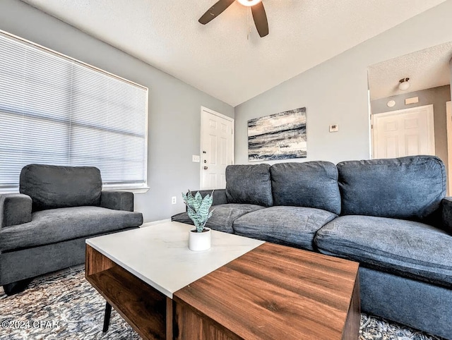 living room featuring a textured ceiling, vaulted ceiling, and ceiling fan