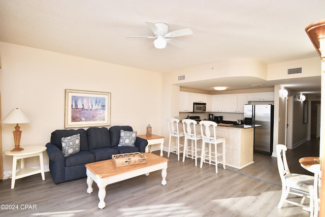 living room with hardwood / wood-style flooring and ceiling fan