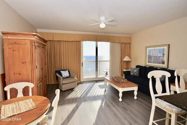 living room with hardwood / wood-style flooring, ceiling fan, and a water view