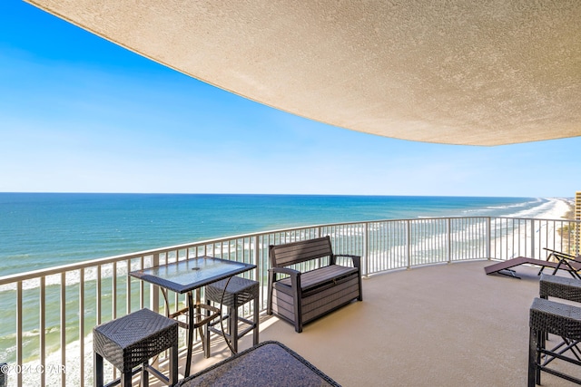 balcony with a water view and a beach view