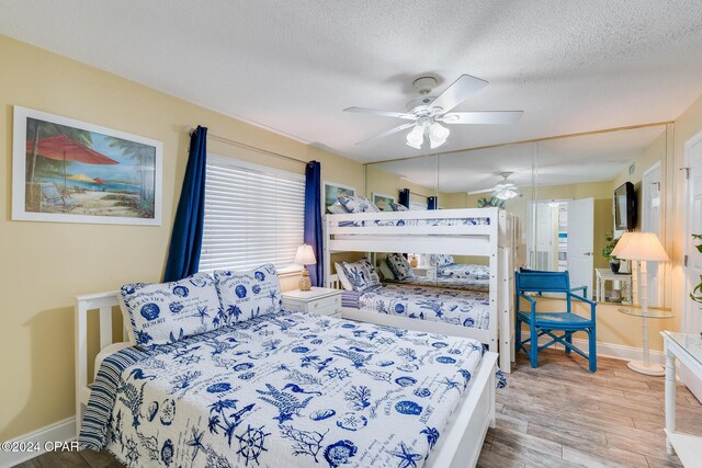 bedroom with wood-type flooring, a textured ceiling, and ceiling fan