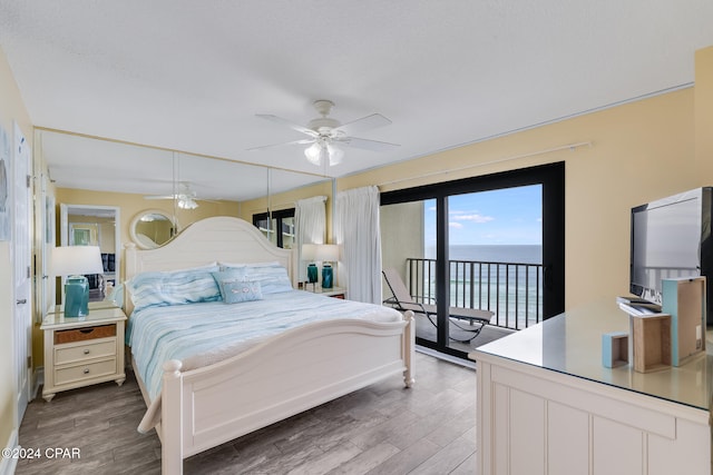 bedroom with access to exterior, ceiling fan, and dark wood-type flooring