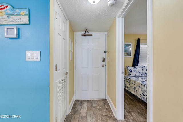 entryway with a textured ceiling and hardwood / wood-style flooring