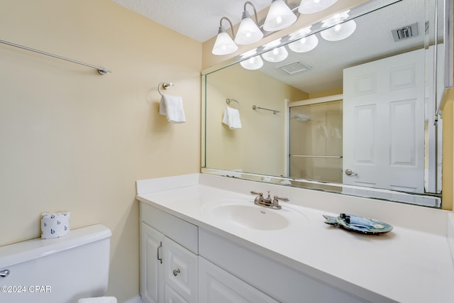 bathroom featuring vanity, a textured ceiling, toilet, and an enclosed shower