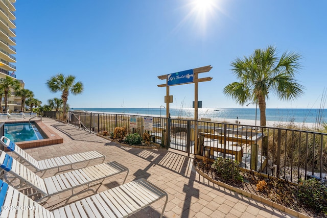 view of patio / terrace with a water view and a view of the beach