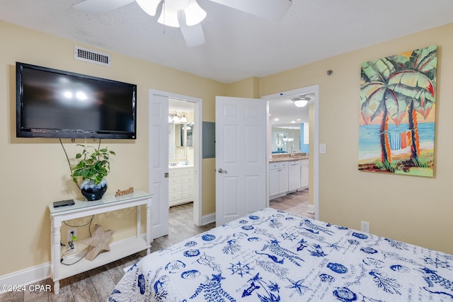 bedroom featuring ensuite bath, ceiling fan, and hardwood / wood-style flooring