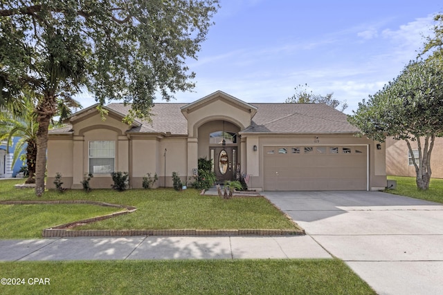 view of front of property featuring a garage and a front lawn