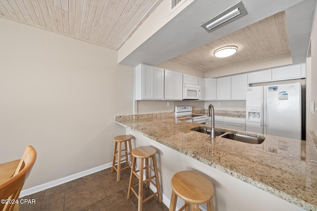 kitchen featuring white cabinetry, sink, wood ceiling, light stone countertops, and white appliances