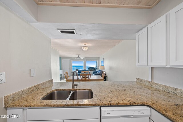 kitchen with white cabinetry, sink, ceiling fan, white dishwasher, and light stone countertops