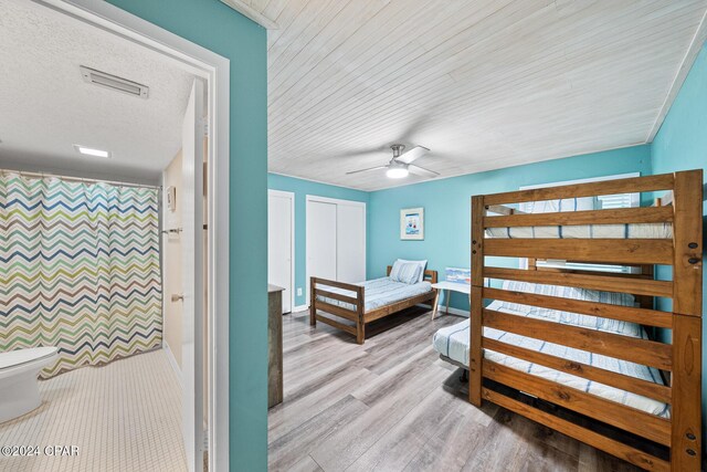 bedroom featuring ceiling fan, a closet, light hardwood / wood-style flooring, and a textured ceiling