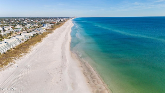 birds eye view of property with a water view and a beach view