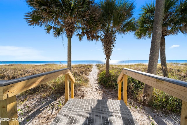 surrounding community with a water view and a beach view