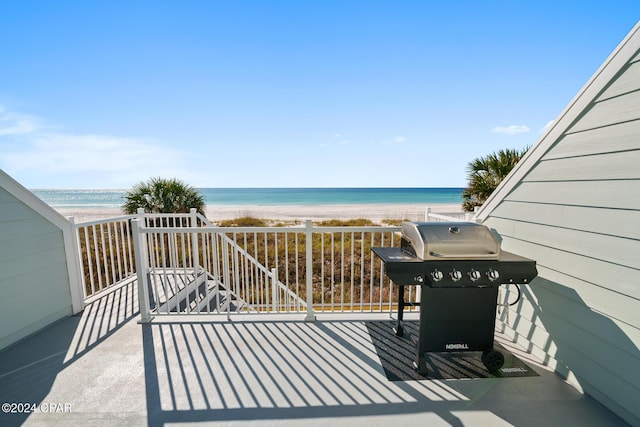 wooden deck featuring a water view, area for grilling, and a beach view