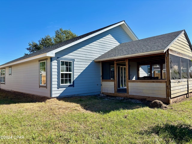 view of front of home with a sunroom and a front yard