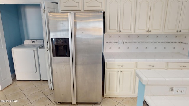 kitchen featuring backsplash, stainless steel fridge, tile counters, and washer and dryer