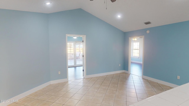 tiled empty room with ceiling fan and vaulted ceiling