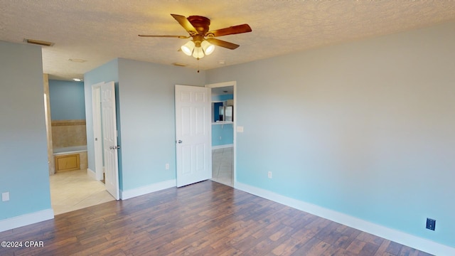 spare room with ceiling fan, light wood-type flooring, and a textured ceiling