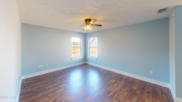 spare room with a textured ceiling, dark hardwood / wood-style flooring, and ceiling fan