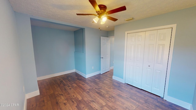 unfurnished bedroom featuring a textured ceiling, ceiling fan, a closet, and dark hardwood / wood-style floors