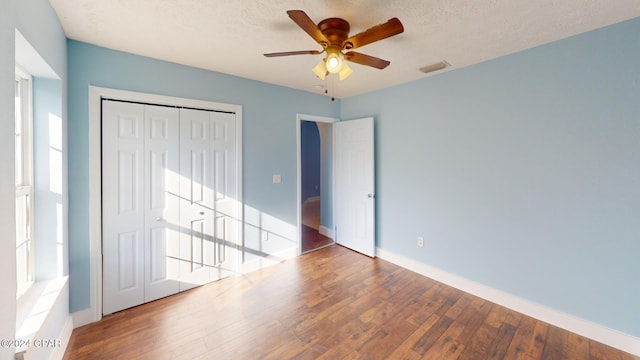 unfurnished bedroom featuring ceiling fan, wood-type flooring, and a textured ceiling