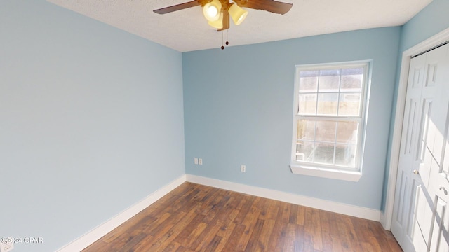 unfurnished room featuring a textured ceiling, ceiling fan, and dark wood-type flooring